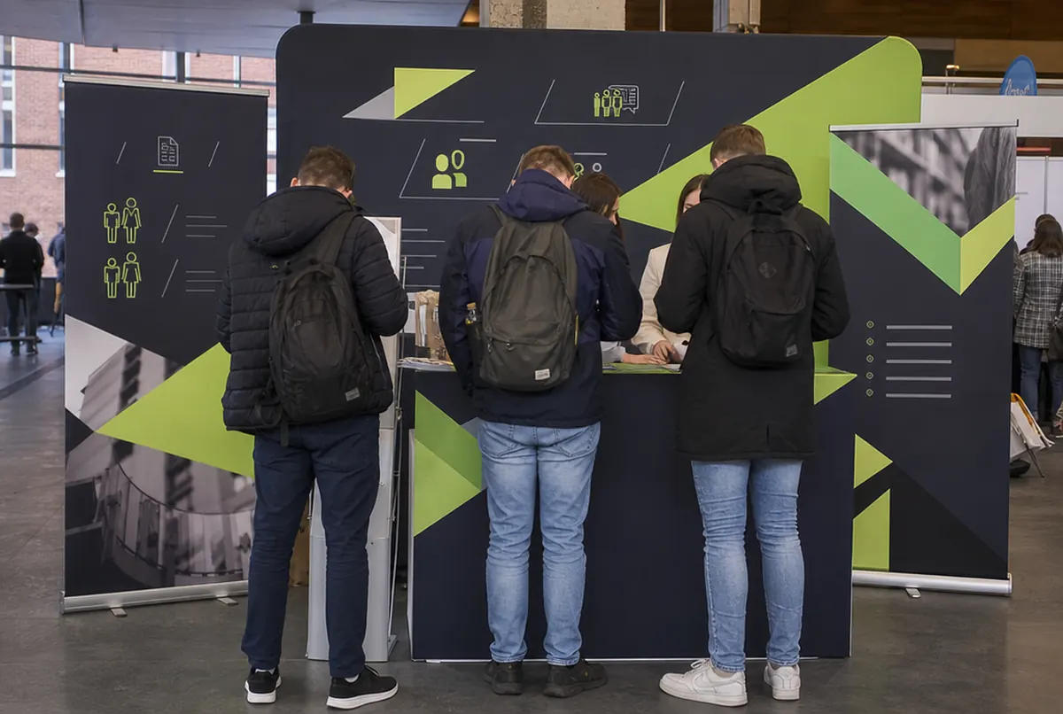 Stand eines Personaldienstleisters auf einer Jobmesse mit Messewand und Theke