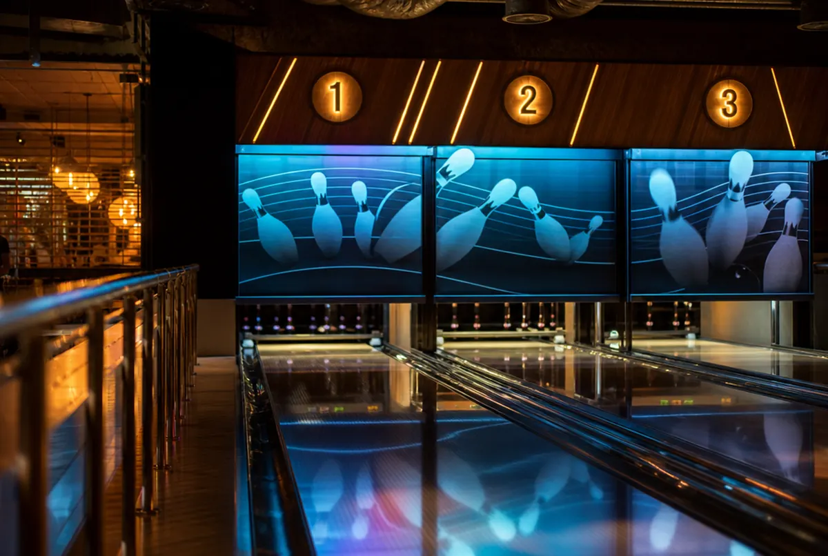 Bowling alley with illuminated lane markers and vinyl wall graphics