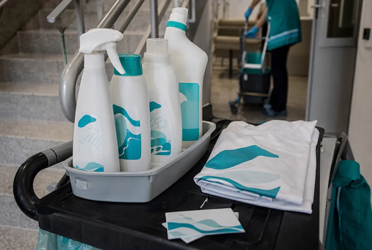 Flaschen mit Etiketten, T-Shirt mit Logo und Visitenkarten einer Reinigungsfirma