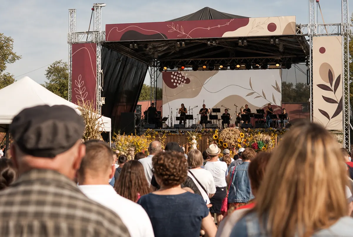 Local harvest festival with a stage, banners, a gazebo and a backdrop