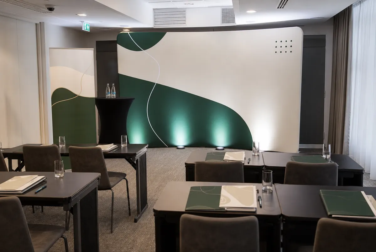 Hotel conference room with a fabric backdrop, a roll-up and notepads