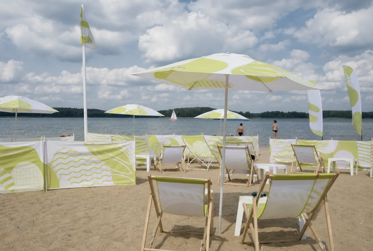 Holiday park beach with printed parasols, sunloungers and windbreaks