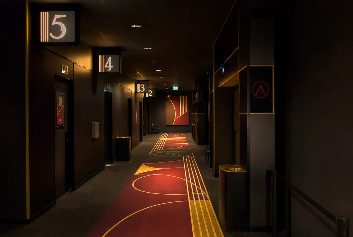 Cinema corridor with illuminated screen numbers and floor graphics