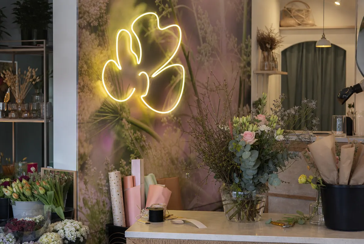 Flower shop interior with a wall mural behind the counter and an LED neon
