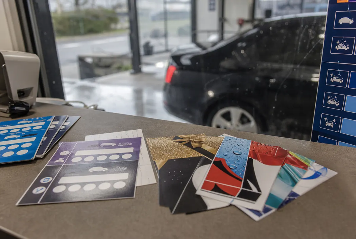 Kundenkarten, Gutscheine und Flyer mit Preisliste der Waschanlage auf der Theke