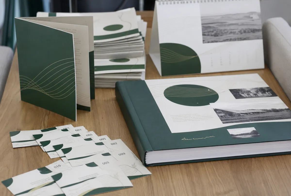 Fundraising cards, leaflets, a wall calendar and an anniversary book on a table