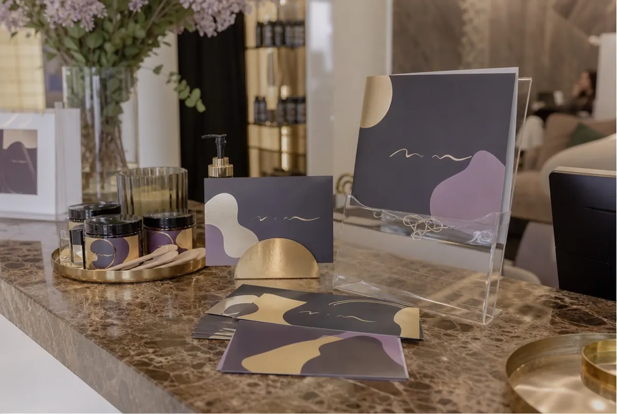 Gutscheine mit Goldprägung, Behandlungskatalog und Etiketten auf Kosmetik