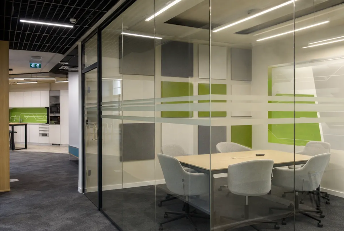 Büro eines IT-Unternehmens mit Besprechungsraum hinter Milchglasfolie und Akustikpaneelen