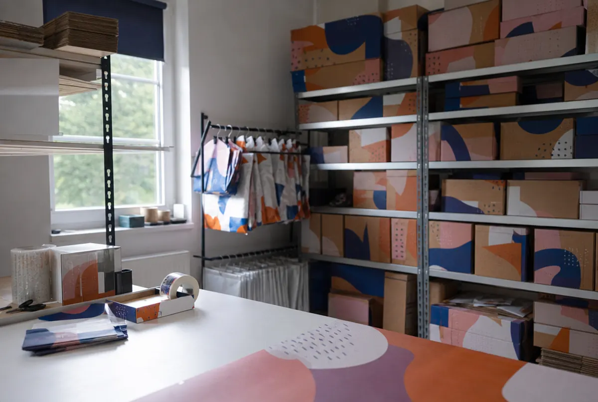 Entrepôt d’une boutique en ligne avec cartons imprimés et ruban adhésif