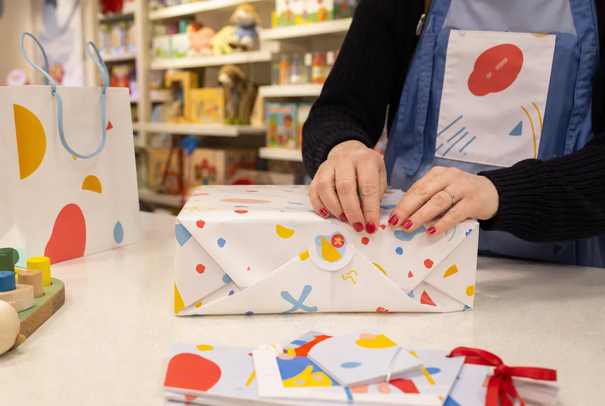 Geschenkpapier mit eigenem Muster, Aufkleber und Geschenkgutscheine im Spielwarengeschäft