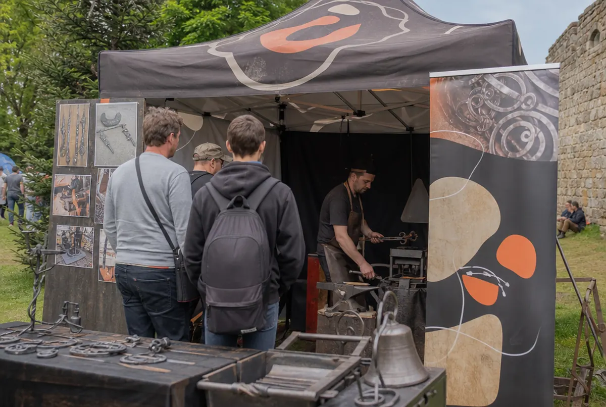 Blacksmith’s stand at a craft fair with a gazebo and roll-up banner