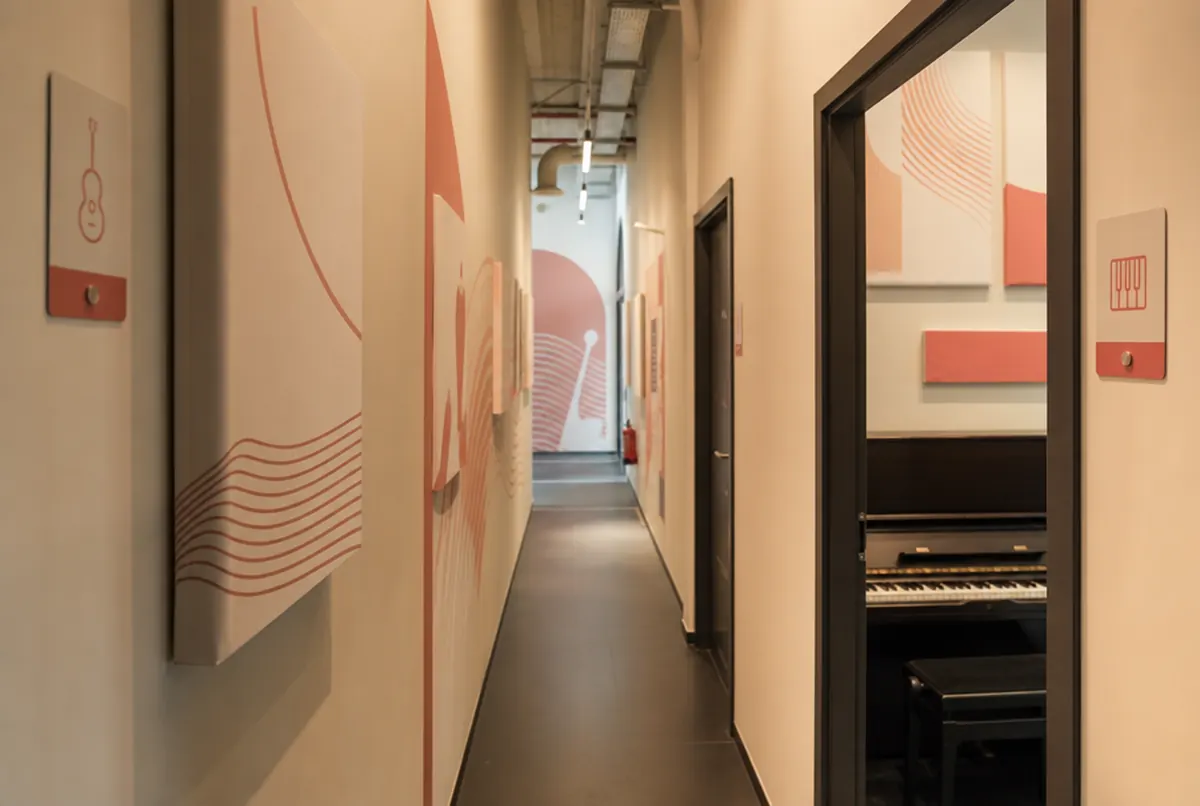 Flur einer Musikschule mit Türschildern und Akustikpaneelen