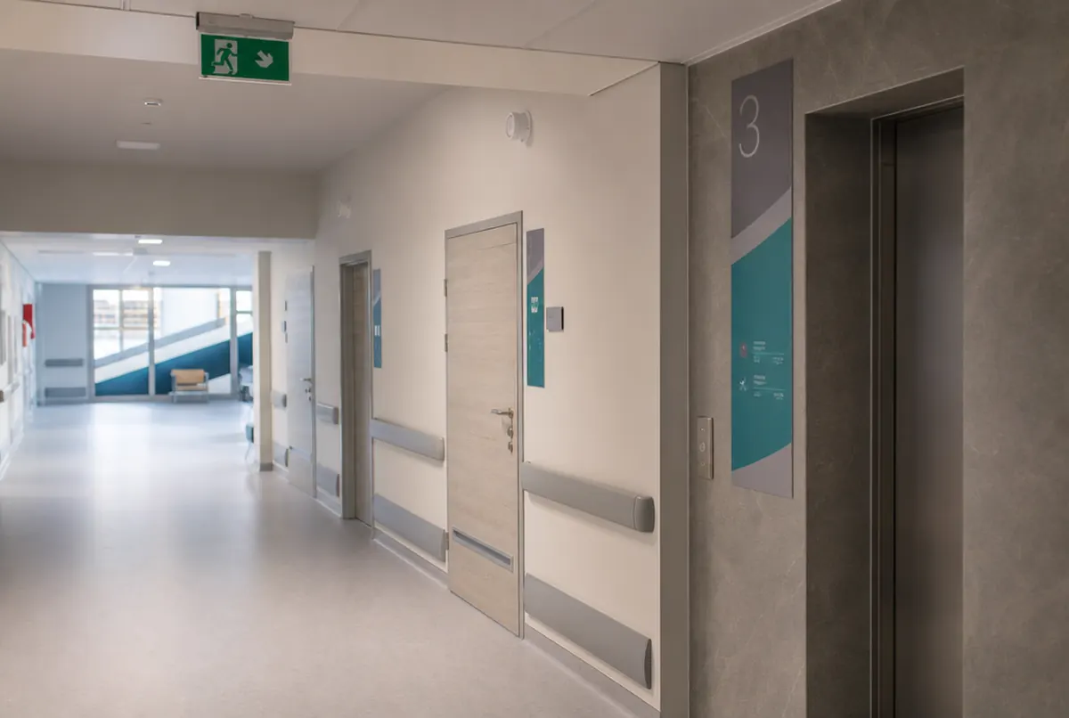 Hospital ward corridor with door signs and floor identification