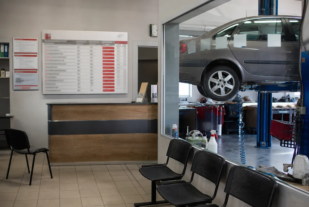 Garage reception with a service price list on a board and signs on the doors