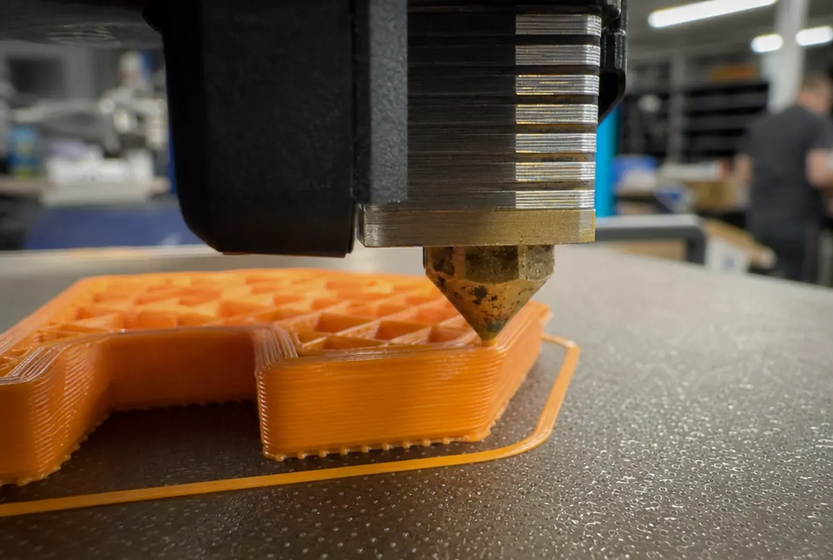 Tête d’imprimante 3D déposant des couches de filament, vue de près