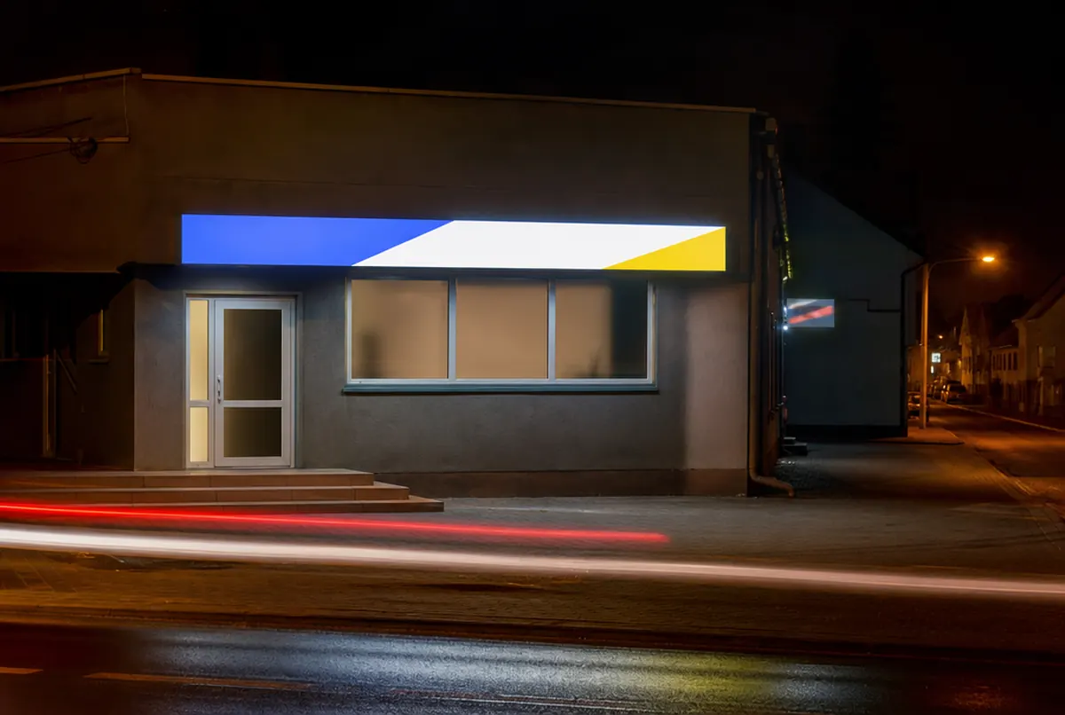 Caisson LED à l’éclairage homogène sur la façade d’un commerce tard dans la nuit