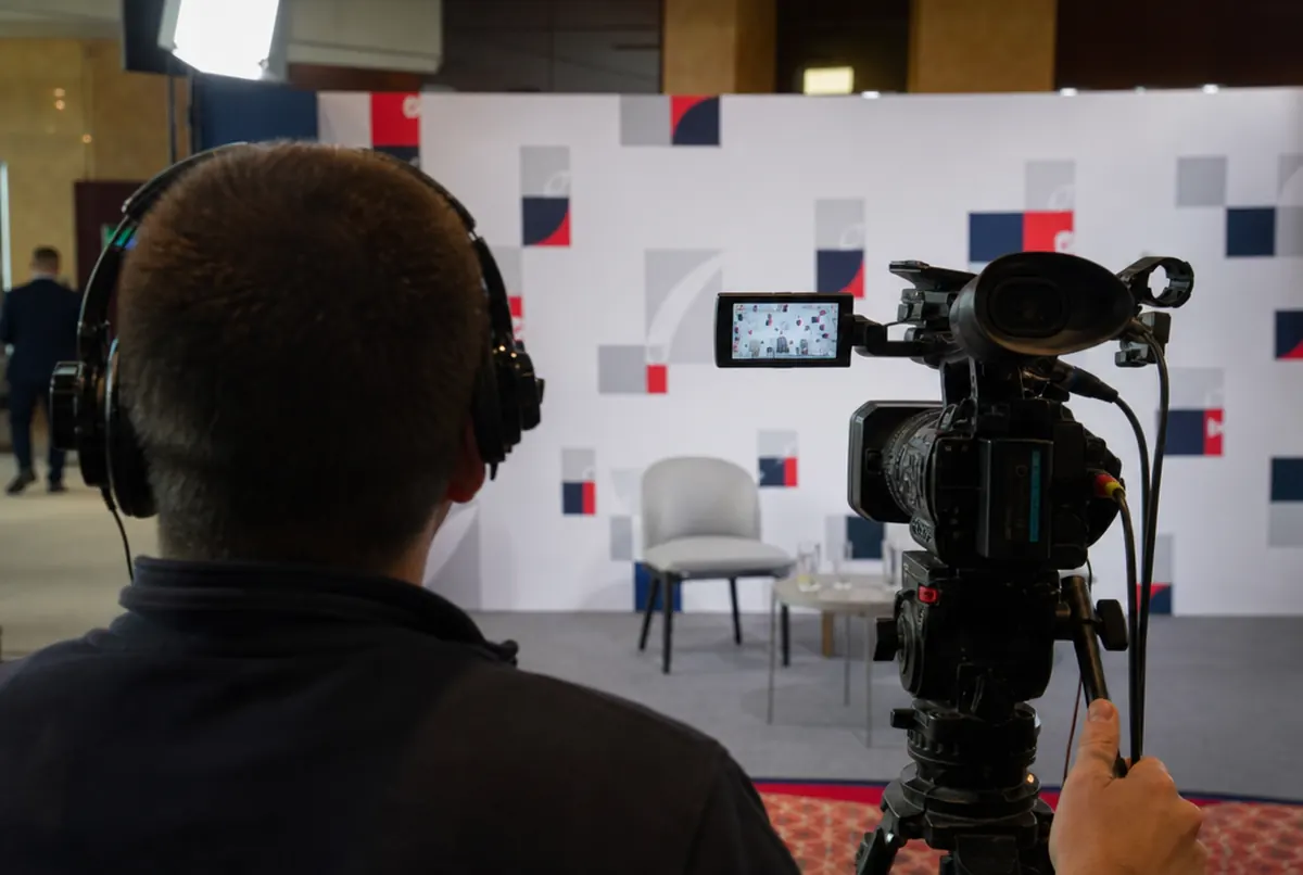 Camera operator framing a sponsor backdrop