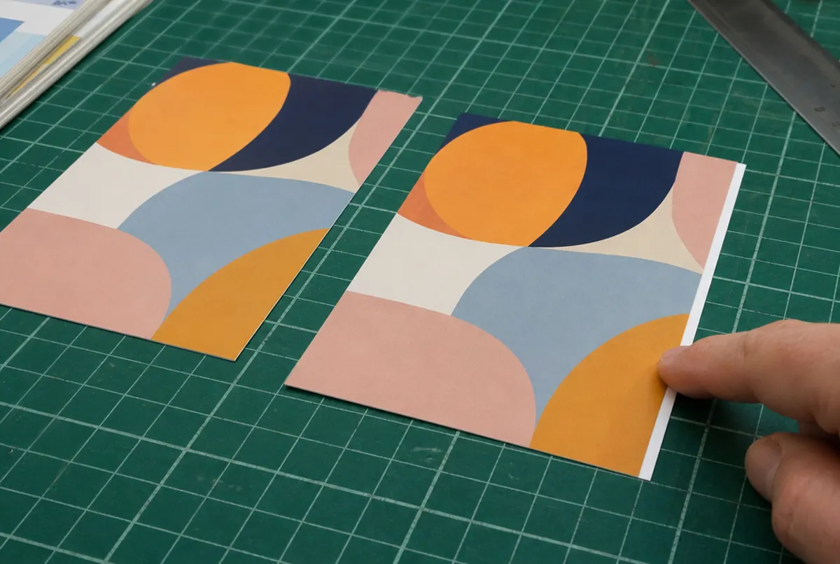 Postcard trimmed with bleed next to a print with a white strip at the edge