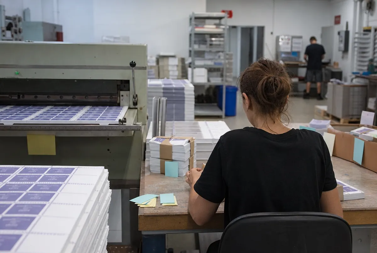 Perforation des planches de billets et mise sous bande à l'atelier