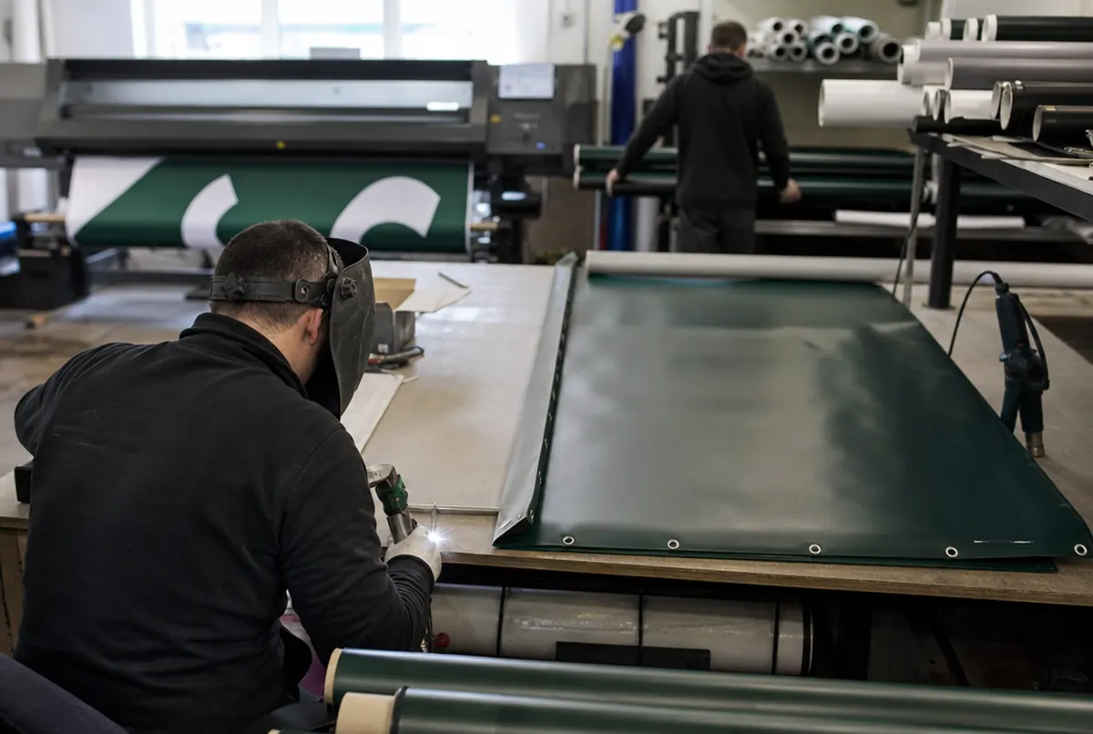 Finishing long court windscreens in the print shop: welded hems and finished rolls