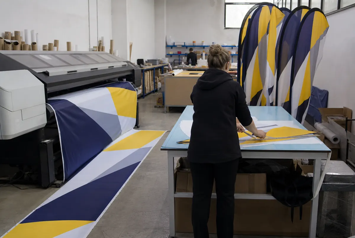 Sublimationsdruck und Zuschnitt segelförmiger Beachflags in der Werkstatt