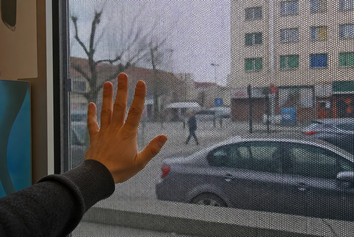 View from inside a shop through OWV-covered glass: the street visible, slightly tinted