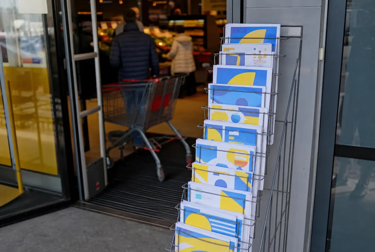 Prospektständer mit Werbeprospekten am Eingang eines Supermarkts