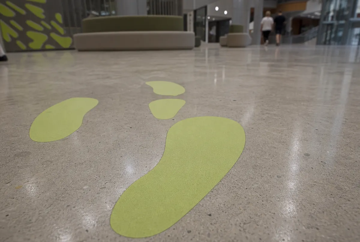 Huellas verde lima troqueladas sobre un suelo de hormigón pulido