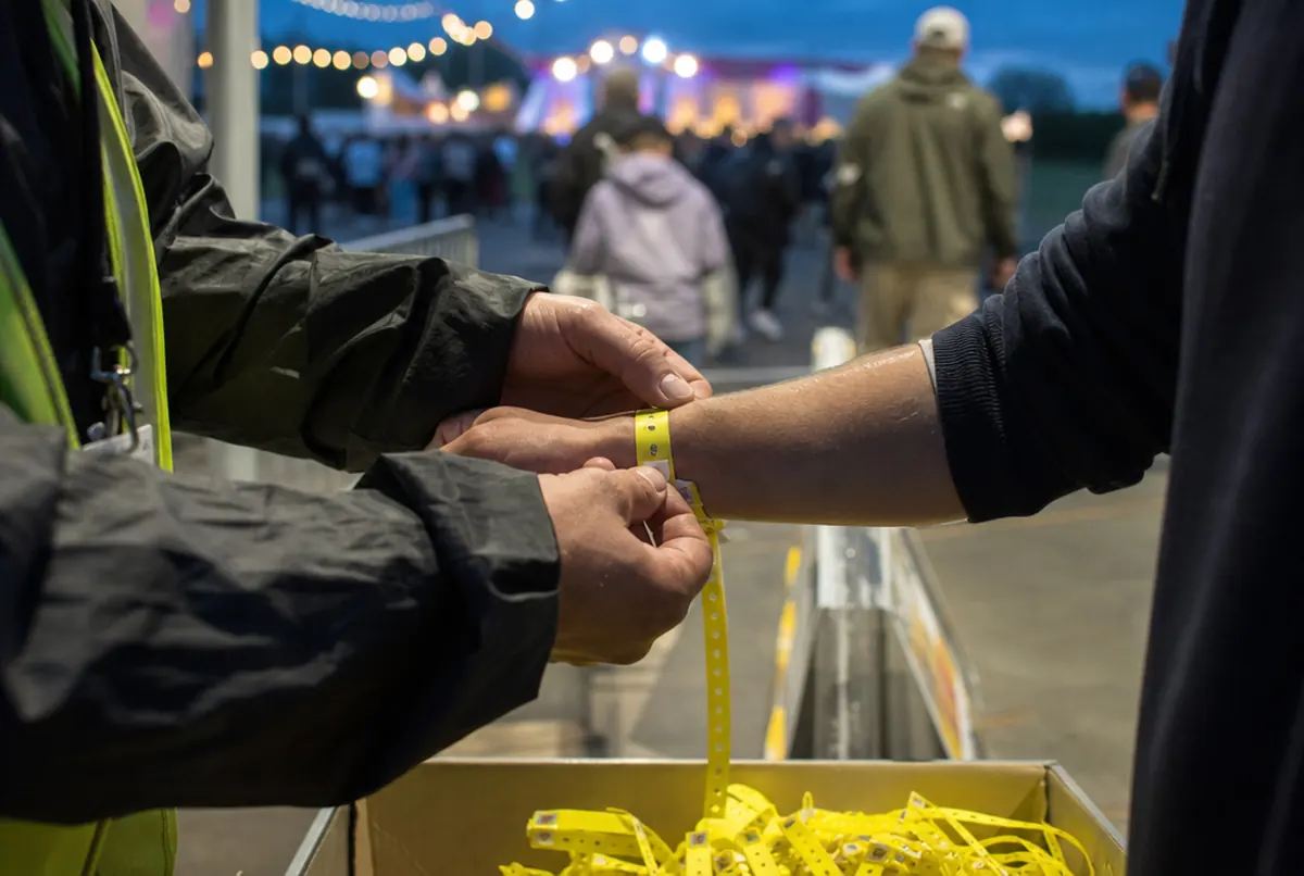 Contrôle d'un bracelet d'entrée numéroté au poignet à l'entrée d'un festival
