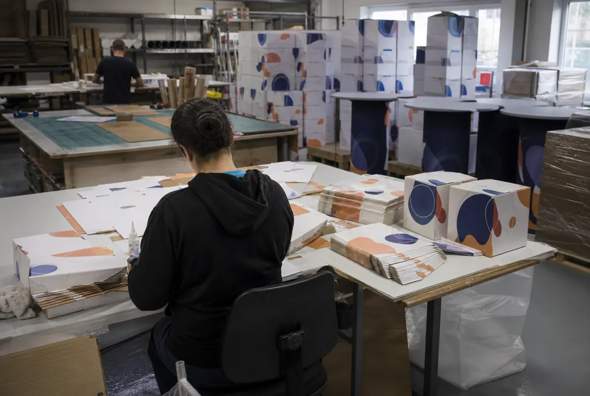 Folding printed blanks into display cubes on the workshop assembly table