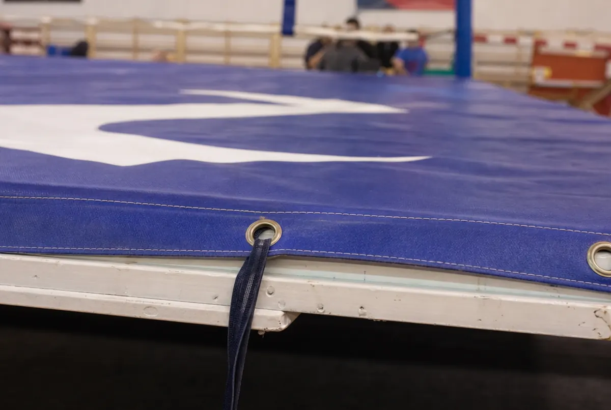 Gros plan du bord cousu d'une bâche de ring avec œillets et sangle
