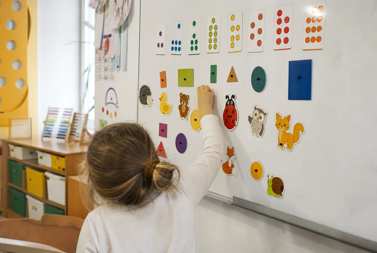 Lernset aus Magnetaufklebern mit Formen und Tieren an der Magnettafel im Klassenzimmer