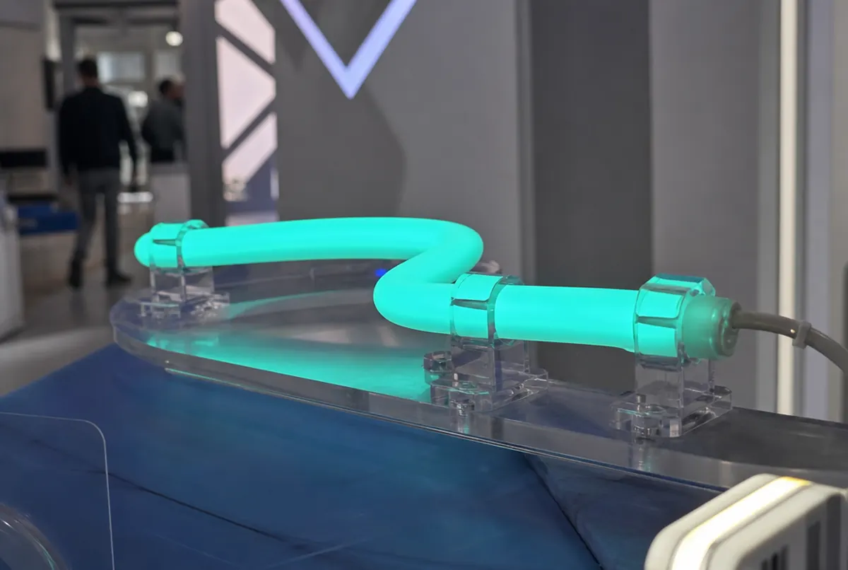 Close-up of a glowing LED flex tube in a silicone sleeve held in clips on acrylic
