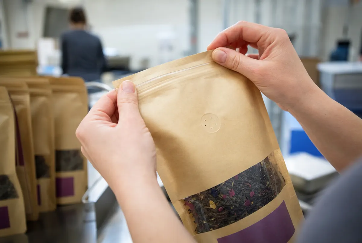 Close-up of a kraft pouch with zip closure, window and tear notch