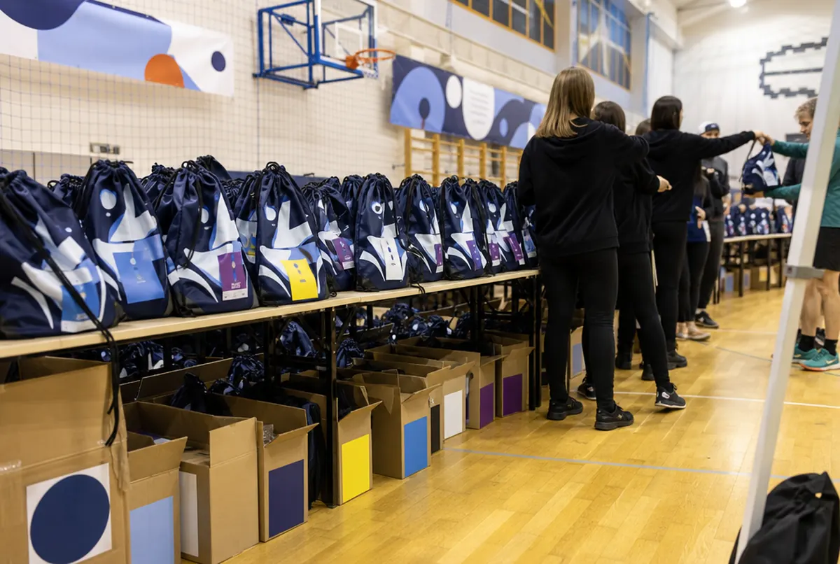 Handing out race packs in drawstring bags at the race office in a sports hall