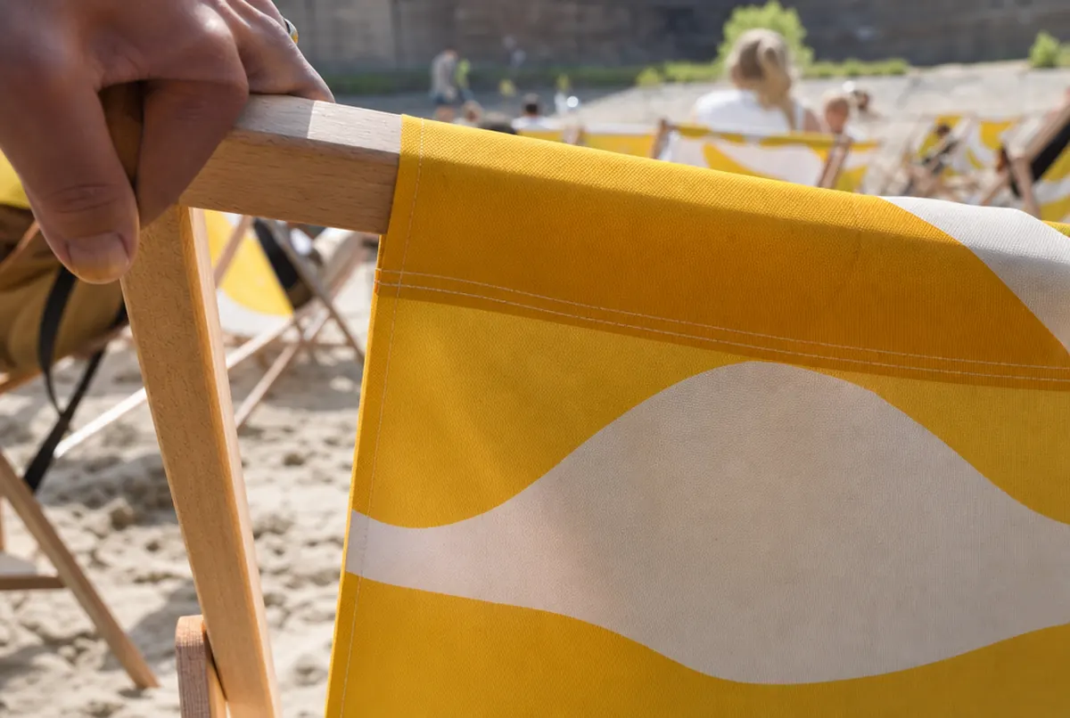 Close-up of a deck chair with printed canvas and a hemmed tunnel on the wooden bar