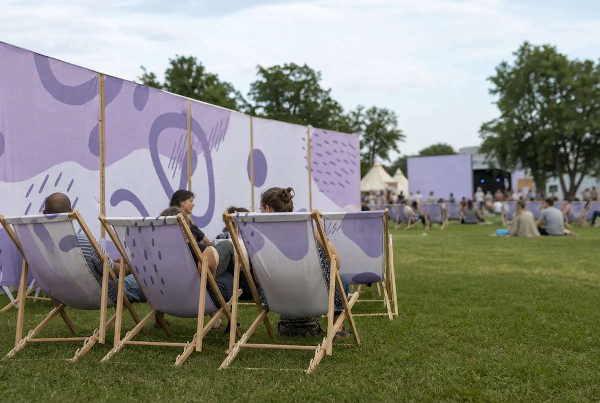 Printed deck chairs and a windbreak screen in a festival chill-out zone