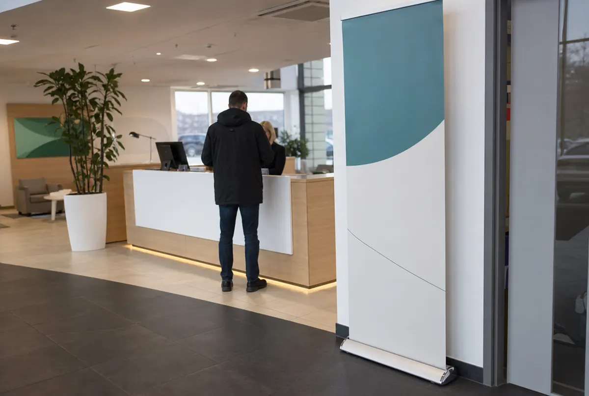 Roll-up mit Alukassette und senkrechter Grafik am Empfang eines Autohauses
