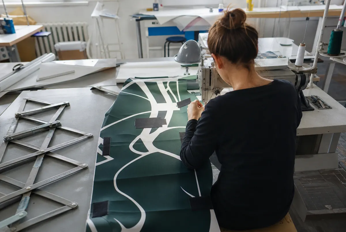 Sewing velcro patches onto a hop-up fabric next to an unfolded frame