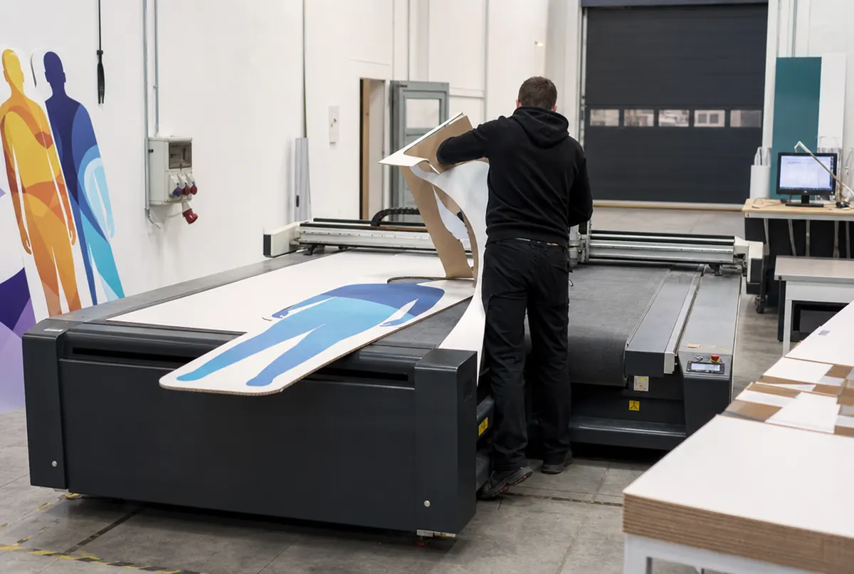 Cutting a totem and figure from honeycomb board along the outline on the cutting table
