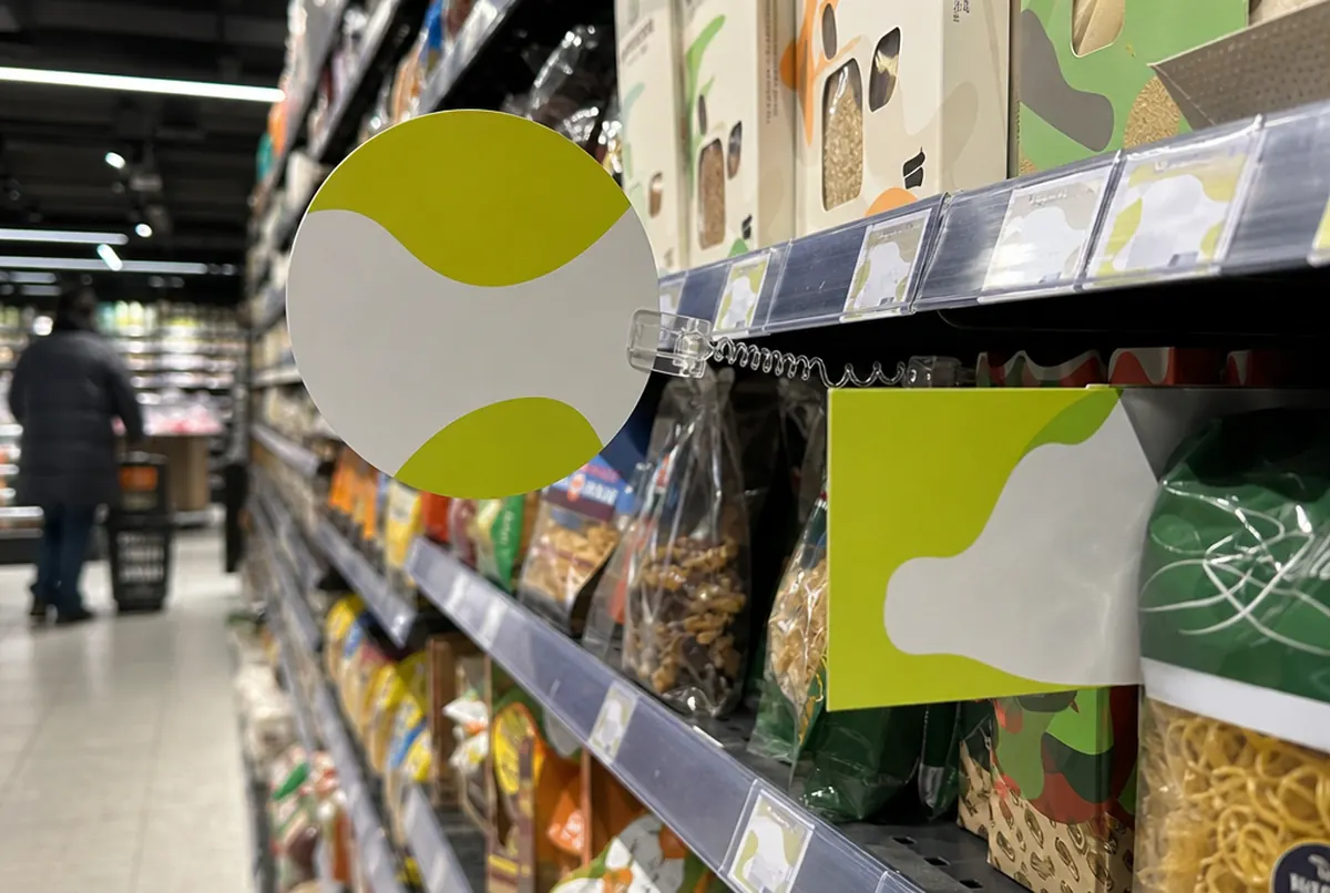 A wobbler on a springy arm and a shelfstopper sticking out from a grocery shelf