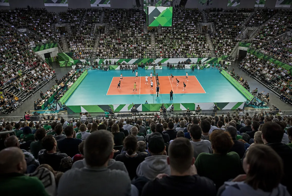 Volleyballhalle von der Tribüne: grün-weiße Werbebanden und Paneele rund um das Spielfeld bei vollen Rängen
